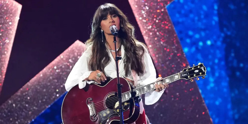 Ella Langley sings holding a guitar on stage.