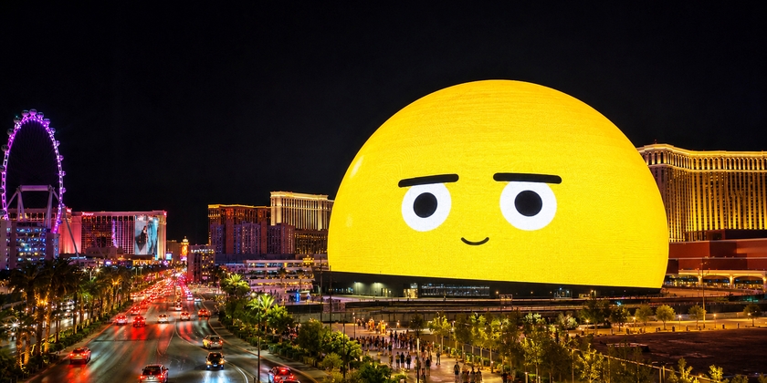 The Sphere in Las Vegas illuminated at night displaying a giant yellow emoji face.