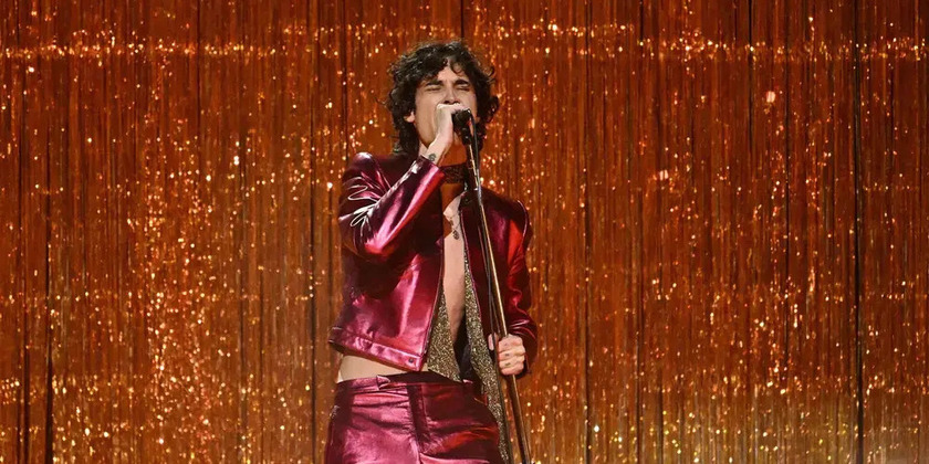 Sombr performs on stage wearing a red sparkly suit.