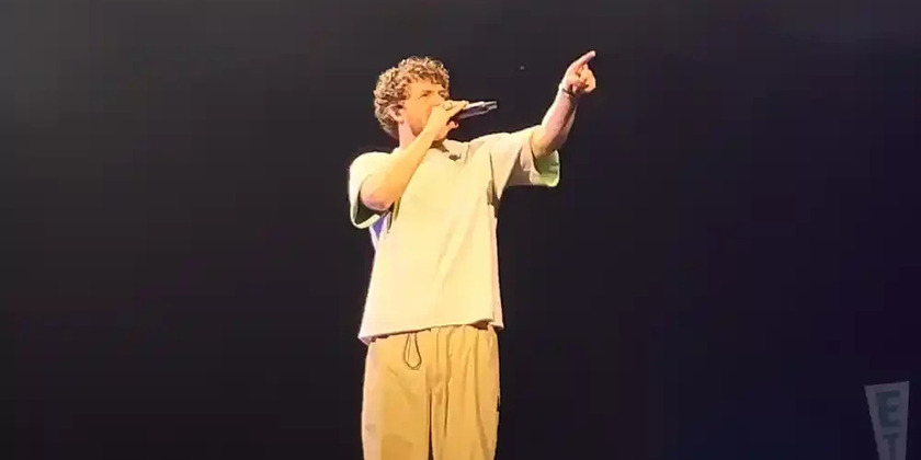 Jack Harlow performs on a stage into a microphone.