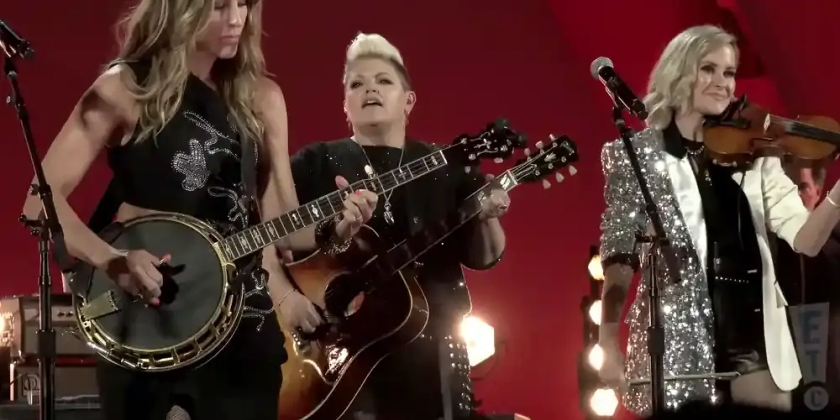 The Chicks perform in front of a red background.