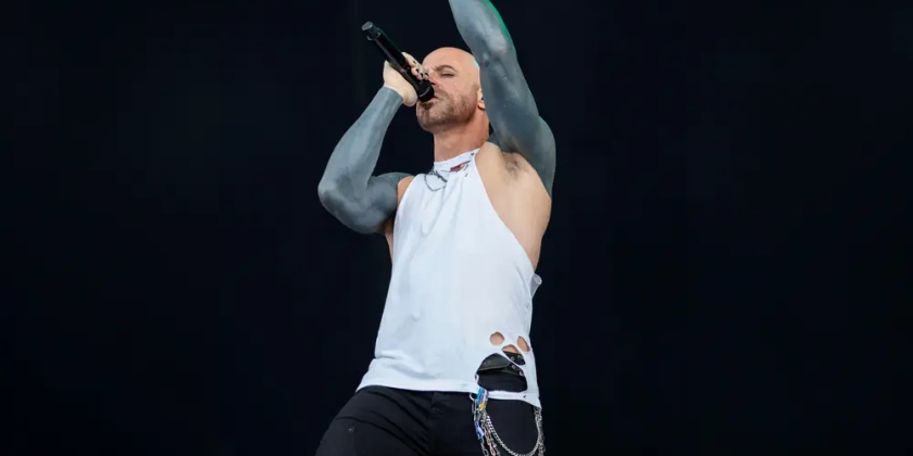 Chris Daughtry performs on stage with his arms outstretched.