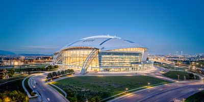 A panoramic view of AT&T Stadium at night.