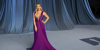 Hilary Duff stands in an elegant eggplant-purple dress.
