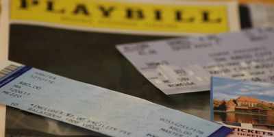 A pile of Broadway tickets, theatre stubs, and show playbills.