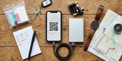 Event essentials items, including a smartphone with a digital ticket and a portable power bank.