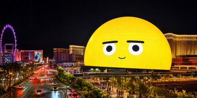The Sphere in Las Vegas illuminated at night displaying a giant yellow emoji face.
