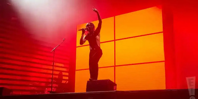 Steve Lacy performs on stage in red lighting.