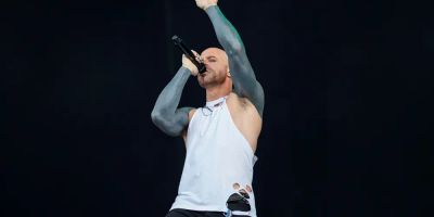 Chris Daughtry performs on stage with his arms outstretched.